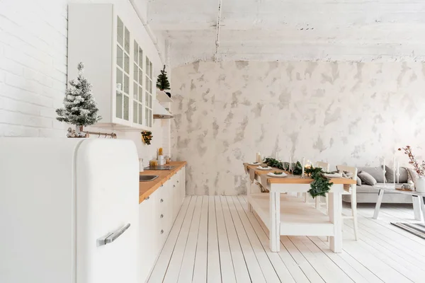 ロフト スタイルのアパートメント ダイニング テーブルとキッチンの大きな広々 としたリビング ルーム クリスマス ツリーが客室です 快適なソファー 高く大きな窓 — ストック写真