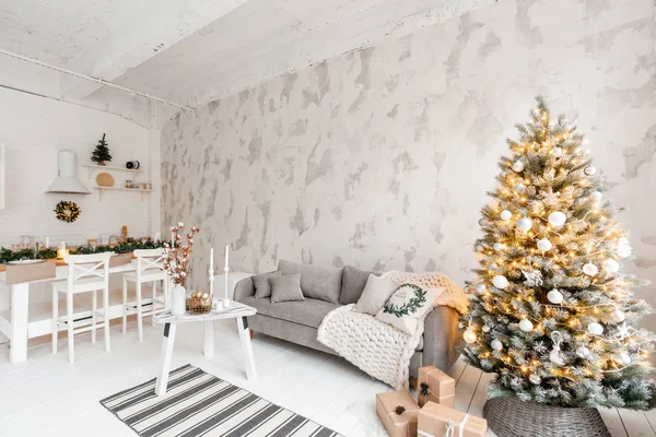 Ljust vardagsrum med julgran. Bekväm soffa, hög stora fönster. Ljus vit tegelvägg. — Stockfoto