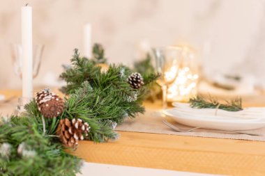 Noel tablo ayarı. Güzel hizmet masa süslemeleri, mumlar ve fenerler. Oturma odası dekore edilmiş ışıklar ve Noel ağacı.