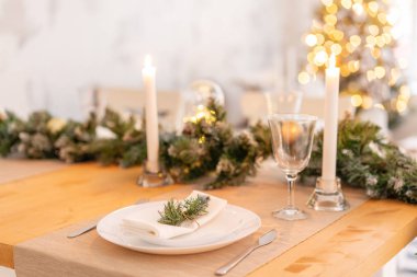 Noel tablo ayarı. Güzel hizmet masa süslemeleri, mumlar ve fenerler. Oturma odası dekore edilmiş ışıklar ve Noel ağacı.