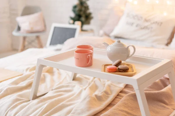 ベッド、一杯のコーヒーとマカロンとトレイでの朝食します。モダンなベッドルームのインテリア。ロマンチックな朝驚き. — ストック写真