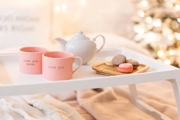 Frukost på sängen, bricka med kopp kaffe och macaroon. Moderna sovrum inredning. Romantisk morgon överraskning. — Stockfoto
