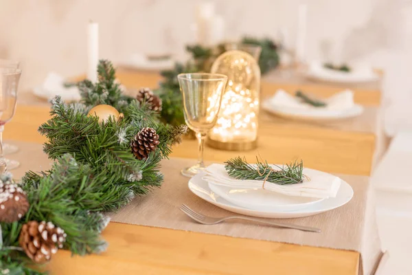 Cenário da mesa de Natal. Bela mesa servida com decorações, velas e lanternas. Sala de estar decorada com luzes e árvore de Natal . — Fotografia de Stock