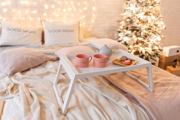 Snídaně v posteli, zásobník s šálkem kávy a makronky. Interiér moderní ložnice. Romantické ranní překvapení. — Stock fotografie