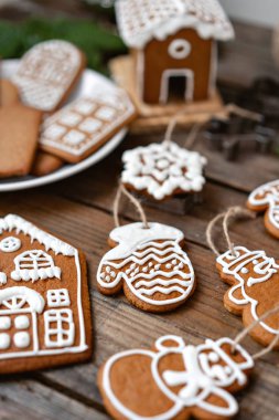 Bir sürü farklı formunda kahverengi ahşap masa, zencefilli bisküvi. Beyaz tatlı sır ile dekore edilmiştir. Noel ruh hali, kış sabahı. Çam dalları ve pişirme için formları