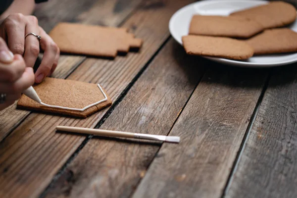 Boş Bisküvi Kurabiye evi dekore etmek hazır. Noel ekmek krema. Bal gingerbread çerezleri üzerinde ahşap kahverengi masa dekorasyon kadın. portre, kopya alanı