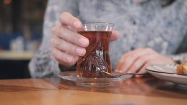 Kupası yakın çekim. Güzel bir kadın içki oryantal sıcak içecek, Türk çayı ve kafede rahatlatıcı. Kahvaltı, keyifli sabah, çalışma gününün başlangıç