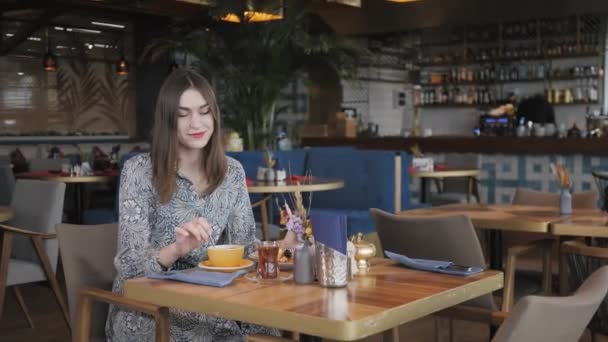 Pretty woman drinking coffee and relaxing in cafe oriental style. Breakfast, pleasant morning, the beginning of the working day — Stock Video