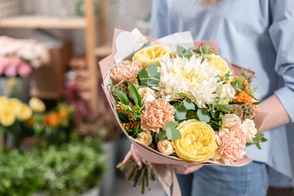 Tienda floral europea. Ramo de hermosas flores mixtas en mano de mujer. Excelentes flores de jardín en el arreglo, el trabajo de un florista profesional . — Foto de Stock