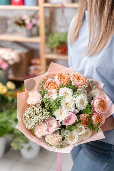 Tienda floral europea. Ramo de hermosas flores mixtas en mano de mujer. Excelentes flores de jardín en el arreglo, el trabajo de un florista profesional . — Foto de Stock