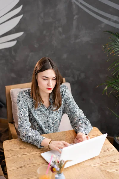 Genç kadın klavyede yazarak, bir blog tutar, sohbet. Freelancer iş modern coworking netbook üzerinde. Başarılı insanlar, işadamı rahat kafede. Yüksek büyük pencereler — Stok fotoğraf