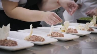 Tabak yemekleri closeup hattı. Grup şefler iyi yemek restoran ticari mutfak meşgul. Personel yemek lezzetli yemek bir restoran ya da otel içinde onlar dekorasyon mutfak yemekleri