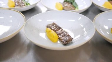 Tabak yemekleri closeup hattı. Grup şefler iyi yemek restoran ticari mutfak meşgul. Personel yemek lezzetli yemek bir restoran ya da otel içinde onlar dekorasyon mutfak yemekleri