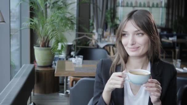 Junge Frau beim Kaffeetrinken. weiblicher Haltebecher vorhanden. Mädchen bloggen, im Internet surfen, chatten — Stockvideo