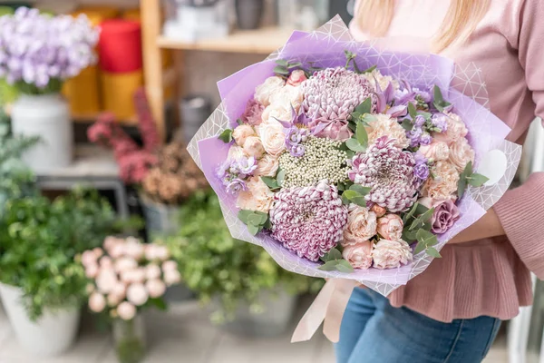 Tienda floral europea. Ramo de hermosas flores mixtas en mano de mujer. Excelentes flores de jardín en el arreglo, el trabajo de un florista profesional . — Foto de Stock