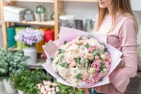 Tienda floral europea. Ramo de hermosas flores mixtas en mano de mujer. Excelentes flores de jardín en el arreglo, el trabajo de un florista profesional . — Foto de Stock