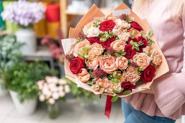 Tienda floral europea. Ramo de hermosas flores mixtas en mano de mujer. Excelentes flores de jardín en el arreglo, el trabajo de un florista profesional . — Foto de Stock