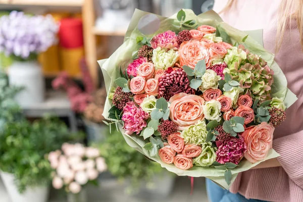 Tienda floral europea. Ramo de hermosas flores mixtas en mano de mujer. Excelentes flores de jardín en el arreglo, el trabajo de un florista profesional . — Foto de Stock