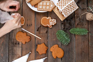 Bir sürü beyaz tabakta Avrupa evler şeklinde zencefilli bisküvi. Beyaz tatlı sır ile dekore edilmiştir. Noel ruh hali, kış sabahı