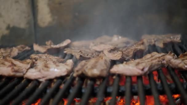 The chef cooking steaks on the grill. Flames and red embers Argentine grill. Fire and grill preparation for barbecue at restaurant. Steak house, Kobe beef, ribeye steak — Stock Video