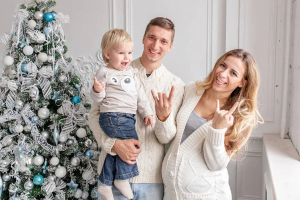 Kameraya dalga geçmeyi. Mutlu aile portresi içinde ana - baba, hamile anne ve küçük oğulları. Yeni Yılınız Kutlu Olsun. süslü Noel ağacı. Noel sabahı parlak oturma odasında. — Stok fotoğraf