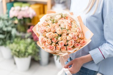 buket sevimli bir kız elinde. Bahçe pembe sprey gül.