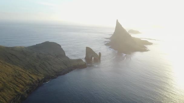 Faerské ostrovy, ostrovy severního Atlantiku v západu slunce. Drangarnir je souhrnný název pro dva zásobníky moře mezi ostrůvkem Tindholmur a ostrov Vágar. Střelba dron quadrocopter, — Stock video