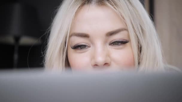 Närbild porträtt av vacker blond kvinna ligger på sängen med grå aluminium laptop. Flicka leenden, gott humör. Blogga, surfa internet, chattar. Glad vinter koncept. — Stockvideo