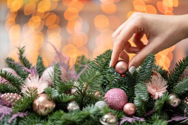 Genç kadın oluşturur ve taze Ladin, süsbitkileri bir rustik ahşap kutu kutu içinde güzel Festival düzenleme süsler. Noel ruh. Garland bokeh arka plan üzerinde.