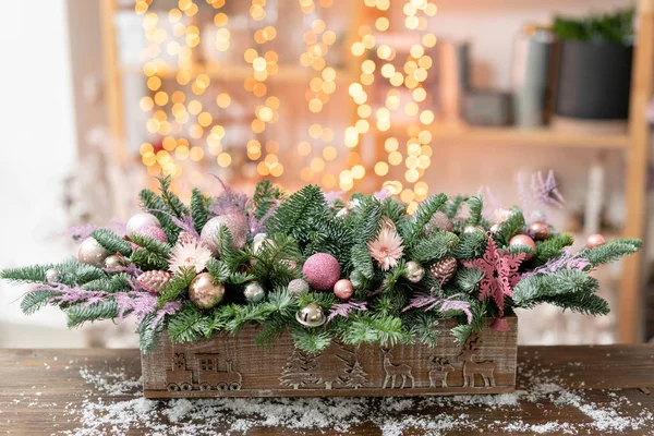 Belo arranjo festivo de abeto fresco, ornamentais rosa em uma caixa de caixa de madeira rústica. Humor de Natal. Garland bokeh em segundo plano . — Fotografia de Stock