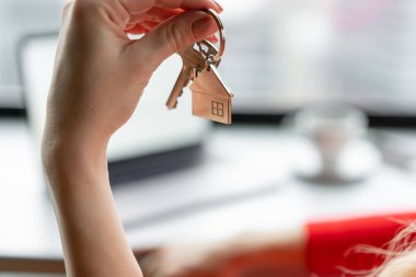 İpotek kavramı. Ev tuşunu basılı tutarak kırmızı mercan iş elbiseli kadın anahtarlık şeklinde. Modern ışık lobi iç. Emlak, hypothec, ana sayfa taşıyarak veya mülkiyet Kiralama.