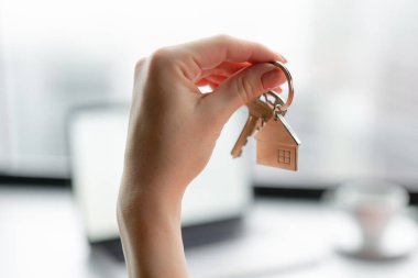 İpotek kavramı. Ev tuşunu basılı tutarak kırmızı mercan iş elbiseli kadın anahtarlık şeklinde. Modern ışık lobi iç. Emlak, hypothec, ana sayfa taşıyarak veya mülkiyet Kiralama.
