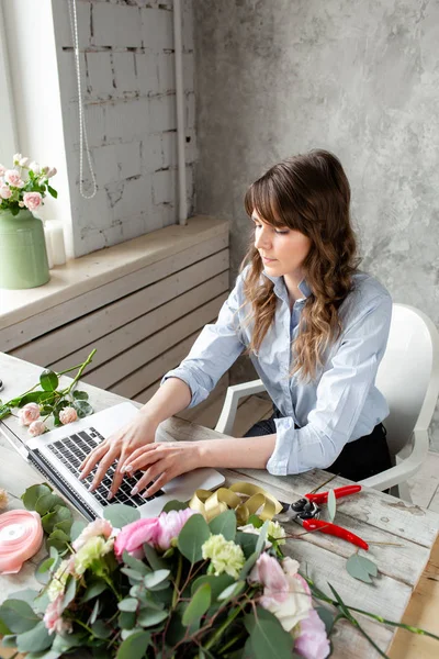 stock image Woman blogger and content creators of social networks and blog flower shop. The concept of online store and floral delivery. SMM promotion. laptop keyboard and desktop of flower shop .