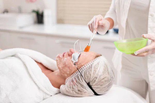 De arts geldt een speciale gel aan de patiënt. Anti acne fototherapie met professionele apparatuur. Mooie vrouw tijdens foto verjonging procedure. Huidbehandeling van gezicht bij cosmetische kliniek. — Stockfoto