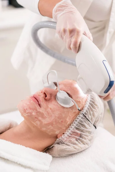 Anti acne fototherapie met professionele apparatuur. Mooie vrouw in de schoonheidssalon tijdens foto verjonging procedure. Laserbehandeling gezicht huid bij cosmetische kliniek. Hardware cosmetologie — Stockfoto