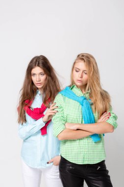 mutlu kız kadın gömlek ve bir kazak onun omuzlarında. İki kız kardeş moda bahar görüntüsü. Renkler renkli kıyafetler. Modelleri ile sarışın ve ışık kahverengi saç.
