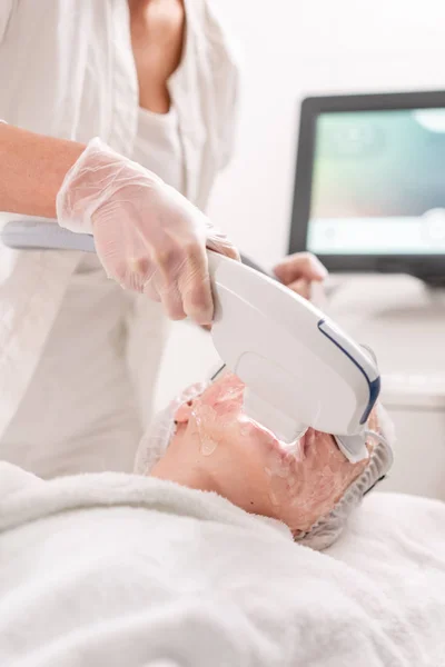 Fototerapia anti acné con equipo profesional. Hermosa mujer en el salón de belleza durante el procedimiento de rejuvenecimiento de fotos. Tratamiento láser de la piel de la cara en la clínica cosmética. Cosmetología del hardware —  Fotos de Stock