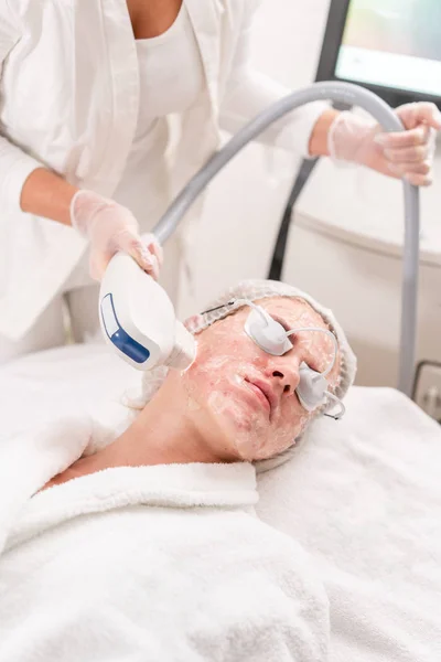 Anti acne fototherapie met professionele apparatuur. Mooie vrouw in de schoonheidssalon tijdens foto verjonging procedure. Laserbehandeling gezicht huid bij cosmetische kliniek. Hardware cosmetologie — Stockfoto