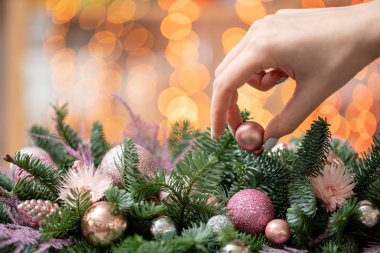 Genç kadın oluşturur ve taze Ladin, süsbitkileri bir rustik ahşap kutu kutu içinde güzel Festival düzenleme süsler. Noel ruh. Garland bokeh arka plan üzerinde.