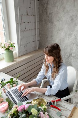 Kadın blogger ve içerik yaratıcıları sosyal ağlar ve blog çiçekçi dükkanı. Online mağaza ve çiçek teslimatı kavramı. SMM promosyon. Laptop klavye ve masaüstü çiçek Shop .