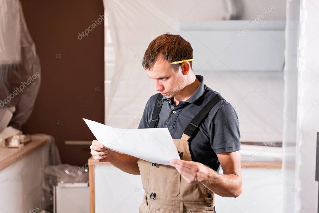 Focused diligent worker inspecting room and planning repairs work. repair of the dining room in the house, kitchen furniture, floor covering change