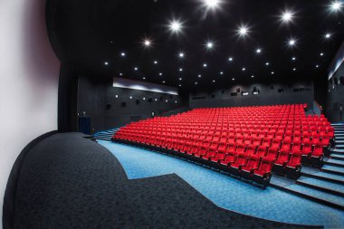 Rusya, Nizhny Novgorod - 29 Mayıs 2014: Ekim sinema. Boş kırmızı sinema salonu koltuk, rahat ve yumuşak sandalyeler. Perspektif oditoryum görünümü