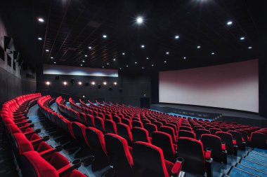 Rusya, Nizhny Novgorod - 29 Mayıs 2014: Ekim sinema. Boş kırmızı sinema salonu koltuk, rahat ve yumuşak sandalyeler. Ekranda beyaz boşluk ile perspektif oditoryum görüntülemek