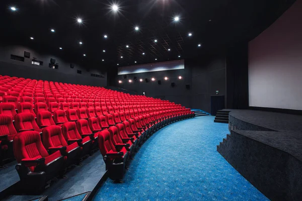 Russia, Nizhny Novgorod - may 29, 2014: October Cinema. Empty red cinema hall seats, comfortable and soft chairs. Perspective auditorium view with white space on the screen — Stock Photo, Image