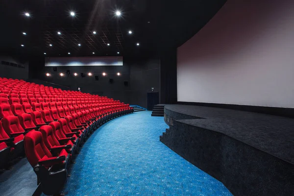 Russia, Nizhny Novgorod - may 29, 2014: October Cinema. Empty red cinema hall seats, comfortable and soft chairs. Perspective auditorium view with white space on the screen — Stock Photo, Image