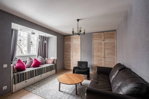 俄罗斯, 下诺夫哥罗德-2018年1月10日, 2018年1月10日: 私人公寓。现代化的客厅配有真皮沙发、扶手椅、木制咖啡桌。舒适的沙发和灯具上的枕头。室内设计 — 图库照片