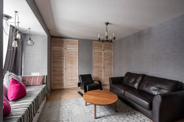 Russia, Nizhny Novgorod - 10 gennaio 2018: Appartamento privato. Soggiorno moderno con divano in pelle, poltrona, tavolino in legno. cuscini su accogliente divano e lampade. Interior design — Foto Stock