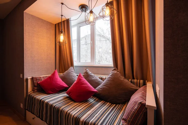 Rusia, Nizhny Novgorod - 10 de enero de 2018: Apartamento privado. Moderno salón con almohadas en un acogedor sofá y lámparas artesanales, diseño de interiores — Foto de Stock