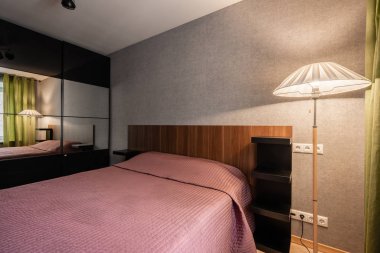 Rusya, Nizhny Novgorod - 10 Ocak 2018: Özel daire. İç tasarım. İç modern küçük yatak odası büyük çift kişilik yatak ile. aynalar ile çalışırken kapaklı dolap.