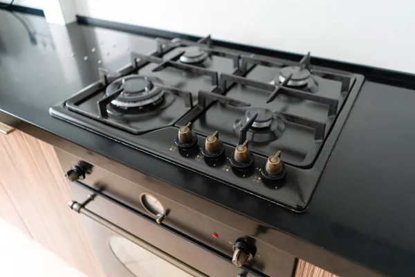 Quemador de gas moderno y vitrocerámica en una cocina. Color negro oscuro y madera Pequeña cocina en un apartamento moderno —  Fotos de Stock